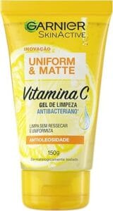 Em um fundo branco, o Gel de Limpeza Facial Antibacteriano Uniform & Matte Vitamina C da Garnier SkinActive (150g) se destaca com sua embalagem amarela vibrante e o desenho de um limão. O produto é ideal para limpeza facial, controle de oleosidade e cuidados com a pele oleosa.